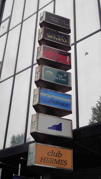 a set of signs on the side of a building for many small bars